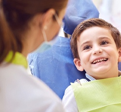 A little boy smiling at his dentist and preparing to have dental sealants placed on her back teeth