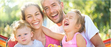 Mother father and two children smiling together