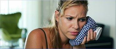 Woman holding ice pack to face