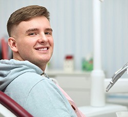 Satisfied dental patient looking over his shoulder