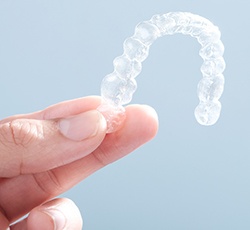 Hand holding an Invisalign tray