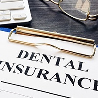 Dental insurance form on a clipboard next to keyboard