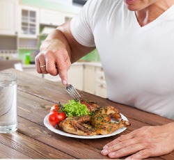 Man eating a healthy chicken dinner