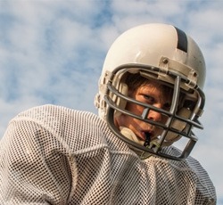 Child playing football and wearing a mouthguard