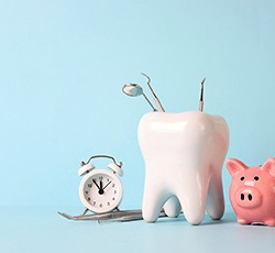 Timer and piggy bank with model of tooth holding dental tools