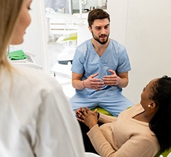 Dentist talking to patient sitting in treatment chair