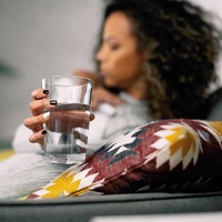 Woman drinking water after dental implant surgery in Lovell