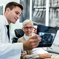 A dentist showing an older patient an X-ray