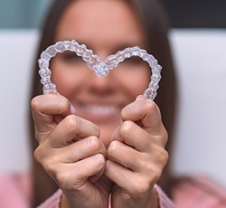 a patient holding two Invisalign trays