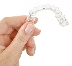 Hand holding a clear aligner