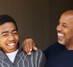 parent resting their arm on their teenager’s shoulder