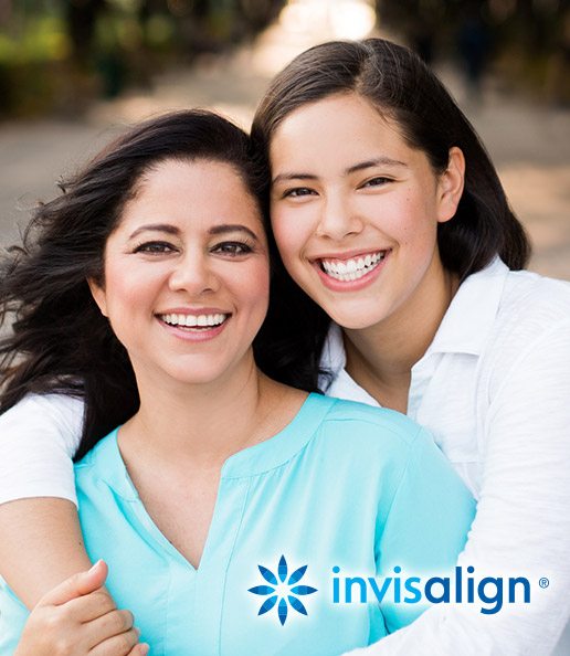 Smiling mother and daughter outdoors