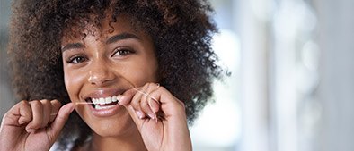 Woman flossing teeth