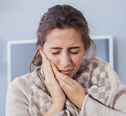 Woman grimacing and holding jaw