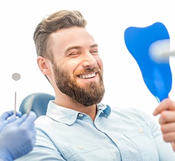 Man admiring his new porcelain veneers in Lovell