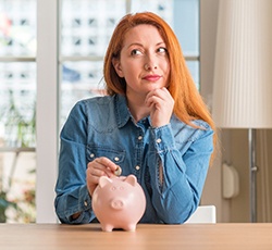 Woman putting coin in piggy bank