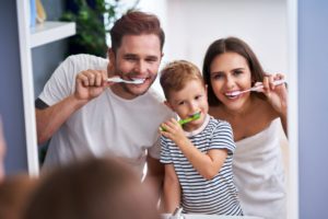 family brushing teeth in front of mirror during quarantine