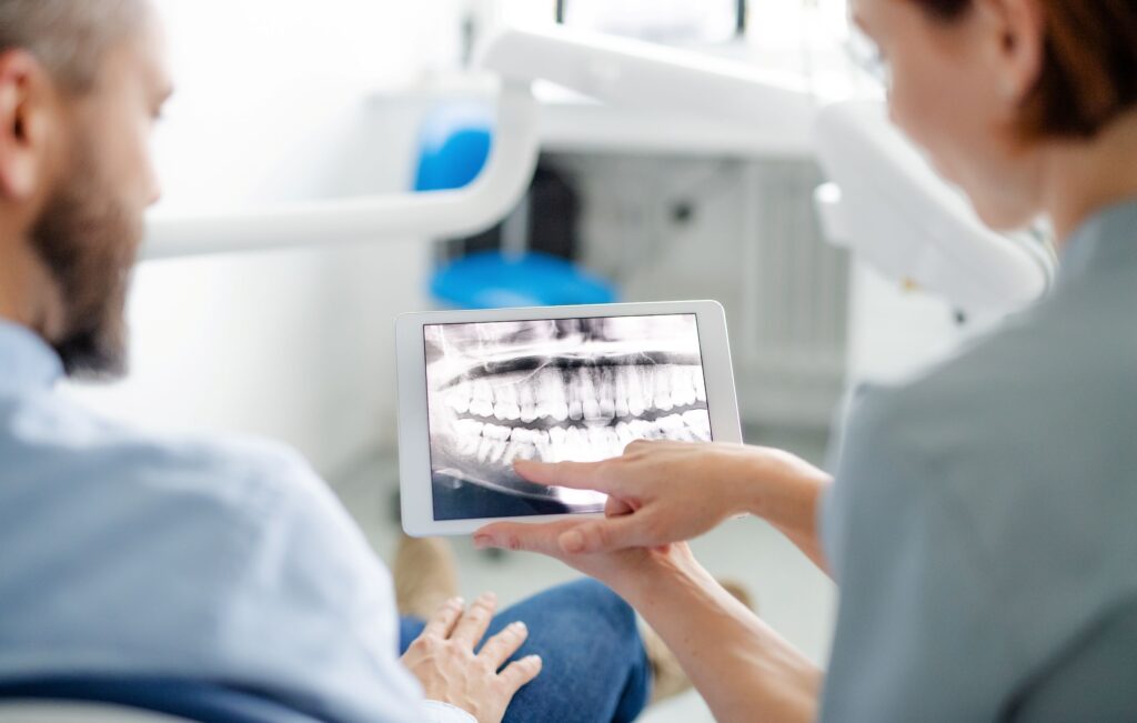 Dentist showing patient his x-rays on tablet device