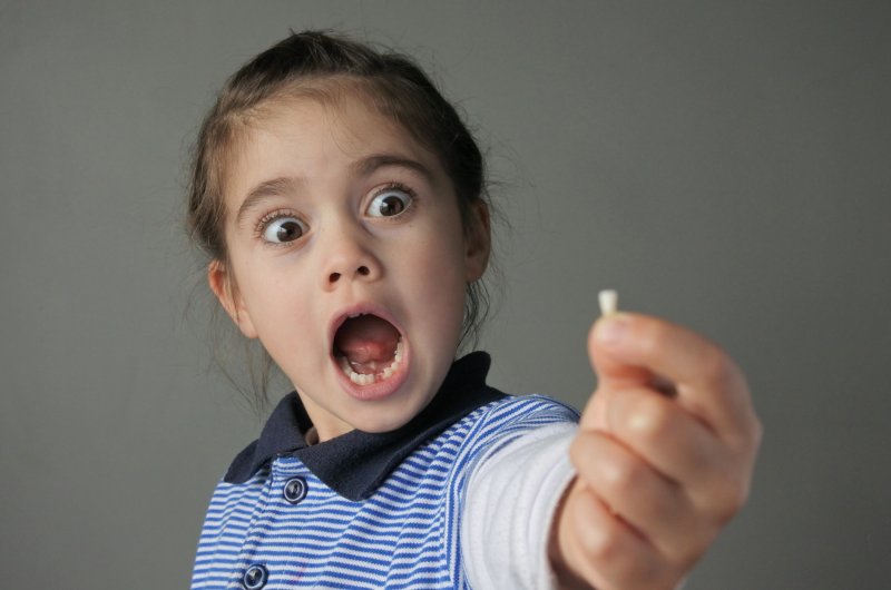 Child holding her baby tooth