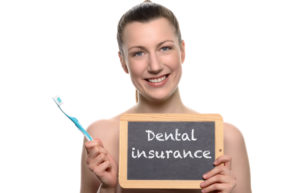 Woman with toothbrush and dental insurance sign